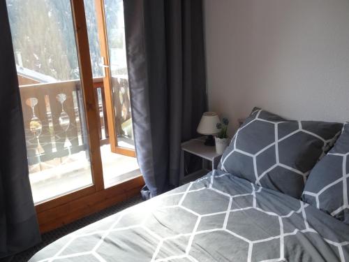 a bedroom with a bed and a window at La Lonzagne in Peisey-Nancroix