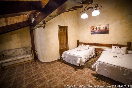 a bedroom with two beds in a room at Casa Rural Castillo Diempures in Cantalojas