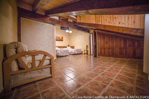 a living room with a chair and a table at Casa Rural Castillo Diempures in Cantalojas