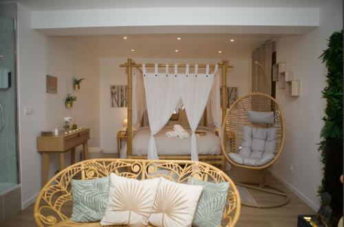 a room with a swing bed and a couch at PARENTHESE LOVE - Bali Mon Amour Suite Balneo SPA Proche Orly-Paris in La Ville-du-Bois