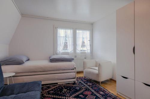 a small bedroom with a bed and a chair at Blattenheimat - im traditionellen Appenzeller Haus in Appenzell