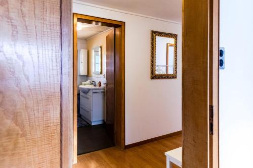 a hallway leading into a bathroom with a sink and a mirror at Blattenheimat - im traditionellen Appenzeller Haus in Appenzell
