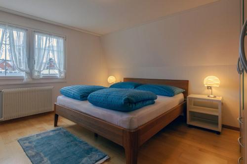 a bedroom with a bed with blue pillows on it at Blattenheimat - im traditionellen Appenzeller Haus in Appenzell