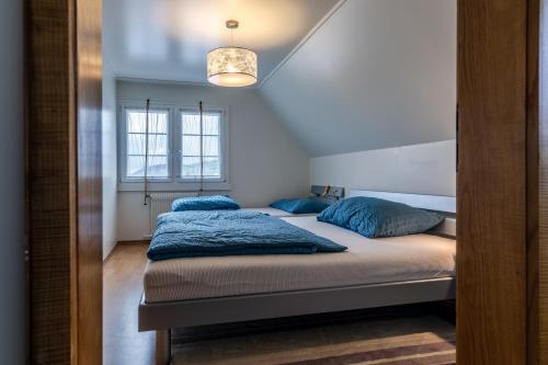 a bedroom with two beds with blue pillows at Blattenheimat - im traditionellen Appenzeller Haus in Appenzell