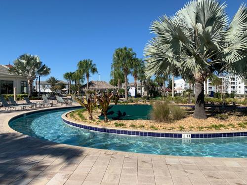 a swimming pool with palm trees in a resort at 3B2B-Beautiful Lake View-Baby Friendly-FREE WATER PARK!NO Resort Fee-5 Miles to Disney-Storey Lake 3141 in Kissimmee