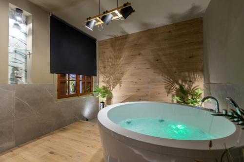 W łazience z drewnianą ścianą znajduje się wanna. w obiekcie NOHO Boutique , premium living Dikeou 8 w Atenach