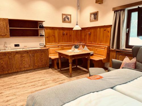 a living room with a table and a kitchen at Pension Kreuzeck - Dein Glücksplatz am Lech in Weissenbach am Lech