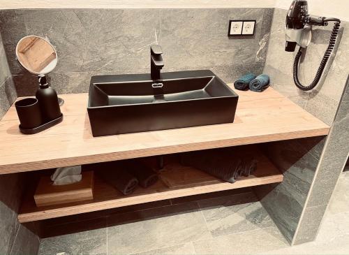 a sink on a wooden counter in a bathroom at Pension Kreuzeck - Dein Glücksplatz am Lech in Weissenbach am Lech