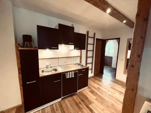 a kitchen with a sink and a ladder in a room at Pension Kreuzeck - Dein Glücksplatz am Lech in Weissenbach am Lech