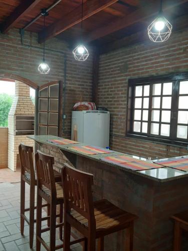 a kitchen with a bar with chairs and lights at Casa/chalé Furnas - Capitólio MG in São José da Barra