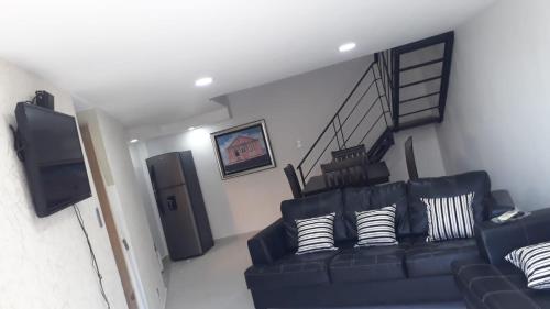 sala de estar con sofá azul y escalera en APARTAMENTO ZONA COLONIAL en Santo Domingo