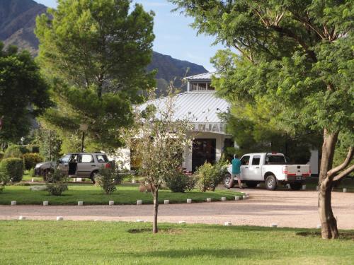 a man walking in front of a white house at Hotel Lujan in Luján