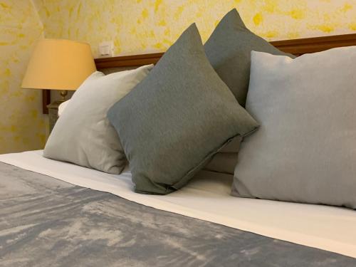 Una cama con cuatro almohadas encima. en Hotel Cristallo Gran Sasso en LʼAquila