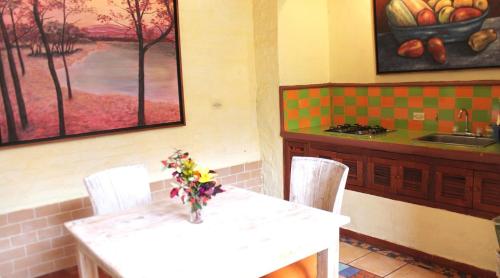 a table with a vase of flowers on it in a kitchen at Suites Arcoiris in Villa de Leyva