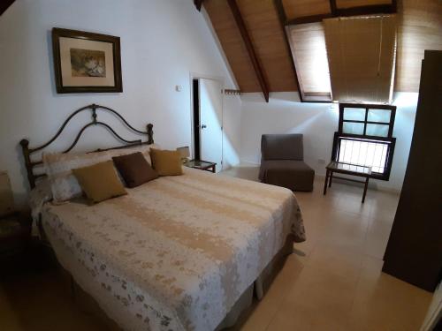 1 dormitorio con 1 cama grande y 1 silla en Ars Amici Hotel, en Punta del Este
