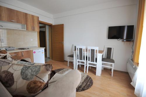 uma sala de estar com um sofá e uma cozinha em Kopaonik Apartman Sanja em Kopaonik