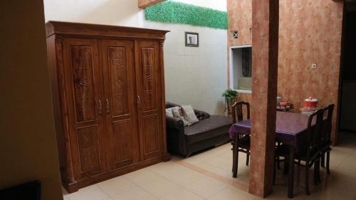 a living room with a large wooden cabinet and a table at Guest House Dissa in Purwokerto