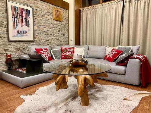 ein Wohnzimmer mit einem Sofa und einem Tisch in der Unterkunft Pirin Golf and Spa Luxury Chalet in Bansko