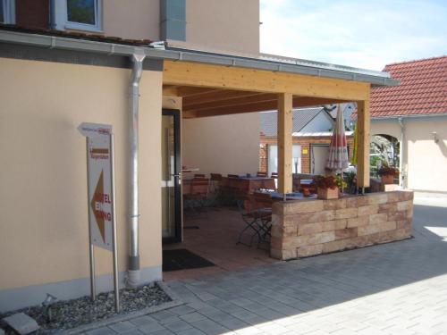 a patio with awning on a building with a table at Hotel Restaurant Bürgerstuben in Altenstadt