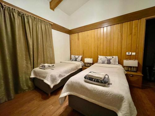 a room with two beds and a window at Pirin Golf and Spa Luxury Chalet in Bansko