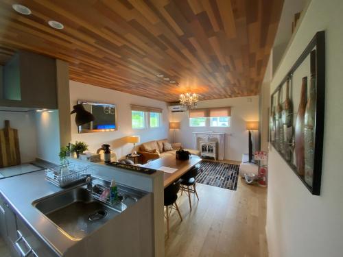 a kitchen and living room with a wooden ceiling at Vacanza Resort in Gifu
