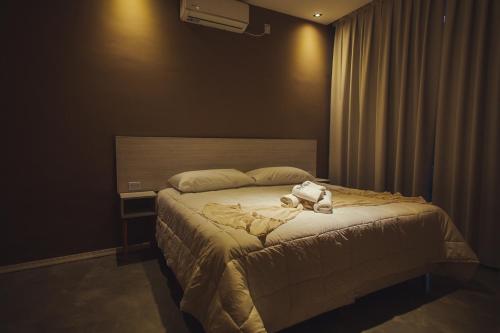 a bedroom with a bed with a stuffed animal on it at Paraiso Natural Apart Hotel Iguazu in Puerto Iguazú