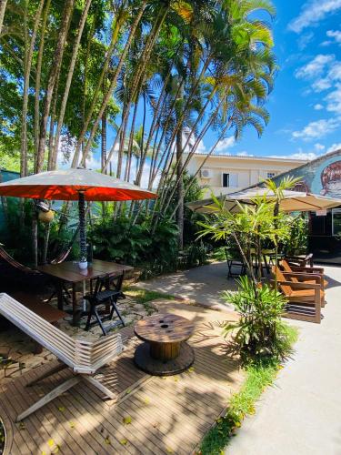 a patio with a table and chairs and an umbrella at Tombo Beach in Guarujá