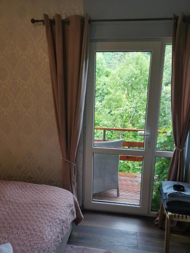 a bedroom with a door open to a balcony at Chic Boutique Apart in Sinaia