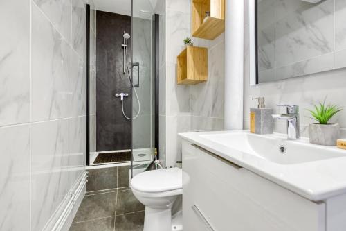 y baño con aseo, lavabo y ducha. en Bee Home Metro 7 + RER C + Easy Check-in + Parking, en Ivry-sur-Seine