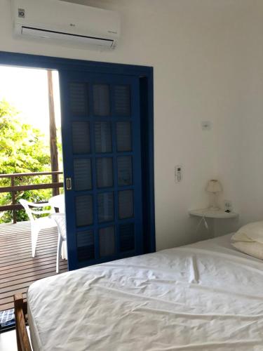 1 dormitorio con 1 cama y puerta con balcón en Casa praia vista mar ttg en Toque Toque Grande