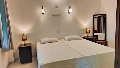 a bedroom with a bed with two lamps on it at Aroma Woods in Hikkaduwa