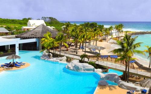 a resort with a pool and a beach with palm trees at Studio Douceur des iles in Belle-Allée