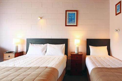 Habitación de hotel con 2 camas y 2 lámparas en 289 Midway Motel, en Oamaru