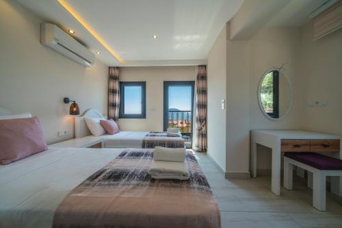 a bedroom with two beds and a desk and a bed at SAKURA VILLA in Fethiye