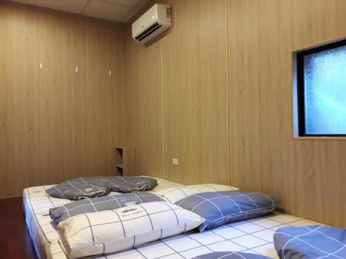 two beds in a room with a air conditioner at Beer Inn綠島 in Green Island