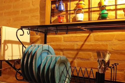 a rack with plates and utensils on a wall at La Villa Chalés in Serra Negra