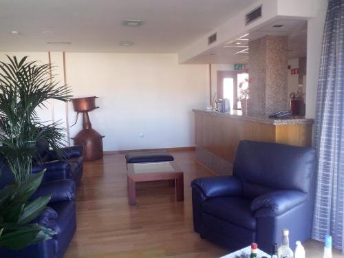 a living room with two blue chairs and a table at Hotel Mirafresno in Miranda do Douro