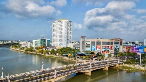 un puente sobre un río en una ciudad con edificios en Căn hộ Khách sạn cao cấp Marina Plaza Long Xuyên, en Ấp Ðông An (1)