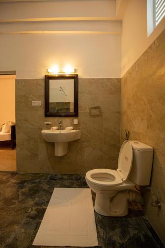 a bathroom with a toilet and a sink at Olu villa Resort in Tissamaharama