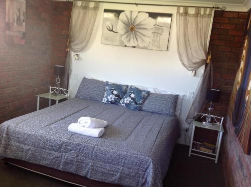 a bedroom with a bed with towels on it at Avlon Gardens Motel in Ballina