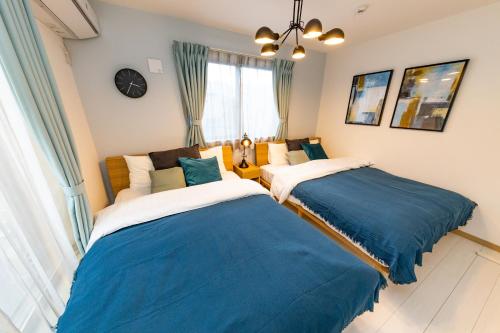 two beds in a room with blue and white at Y's HOTEL KAMEARI in Tokyo