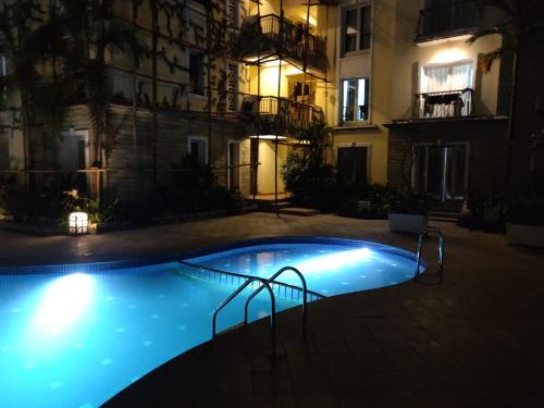 a swimming pool in front of a building at night at Areia De Goa, Comfort Stay Apartment near Baga Beach in Baga