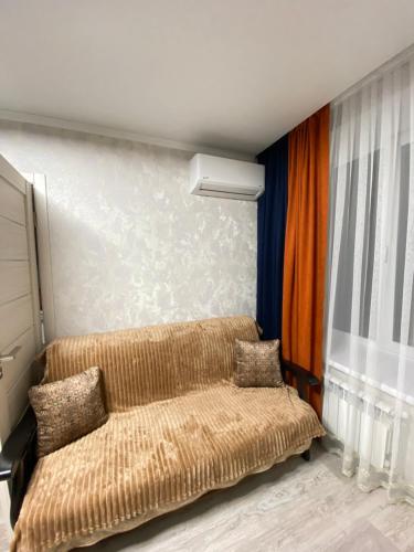 a couch sitting in a room with a window at Люкс апартаменти «Д.І.М.» in Kamianets-Podilskyi