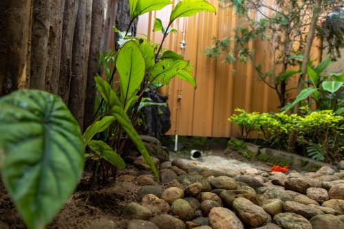 a garden with a fence and a bunch of rocks at Cure Monastery Family Resort in Marayoor