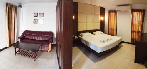 a hotel room with a bed and a chair at Areena Resort and Hotel Uttaradit in Uttaradit