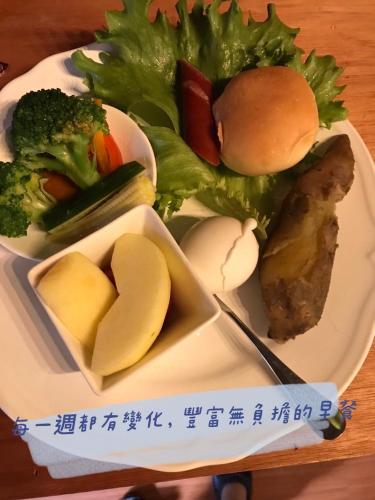 a plate of food with vegetables and meat on a table at 薔薇谷 民宿字108號 in Fuxing