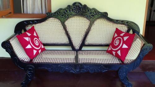 a bench with two pillows on top of it at Green Villa in Hikkaduwa
