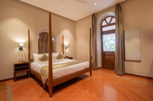 a bedroom with a bed and a large window at R R Heritage Resort Pure Vegetarian in Mahabaleshwar