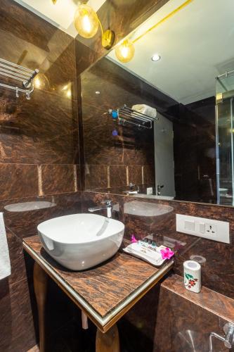 a bathroom with a large white sink on a wooden table at R R Heritage Resort Pure Vegetarian in Mahabaleshwar