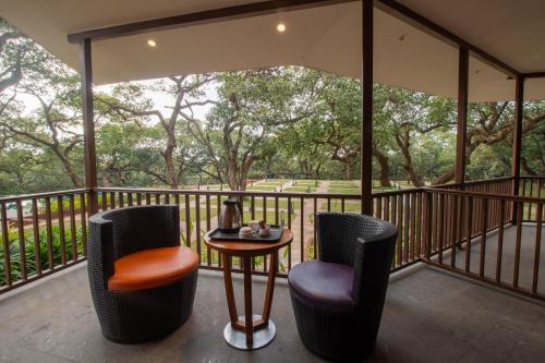 a patio with two chairs and a table on a balcony at R R Heritage Resort Pure Vegetarian in Mahabaleshwar
